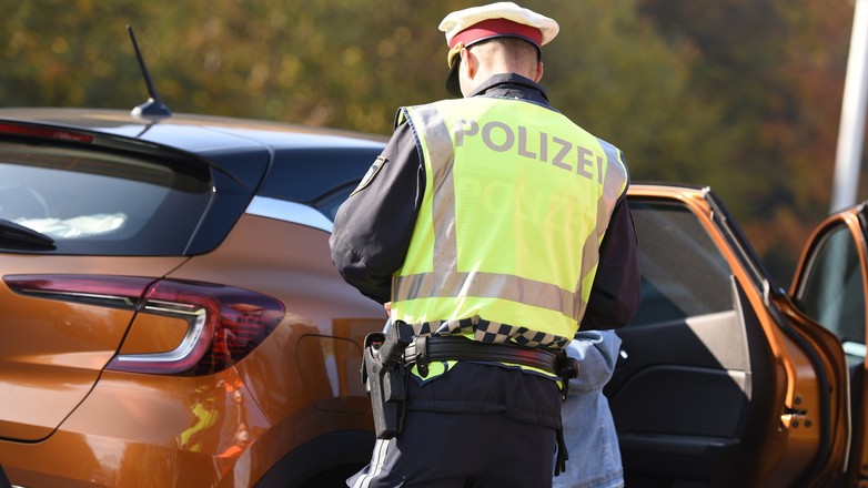 Austriacki policjant wypisujący mandat zatrzymanemu kierowcy