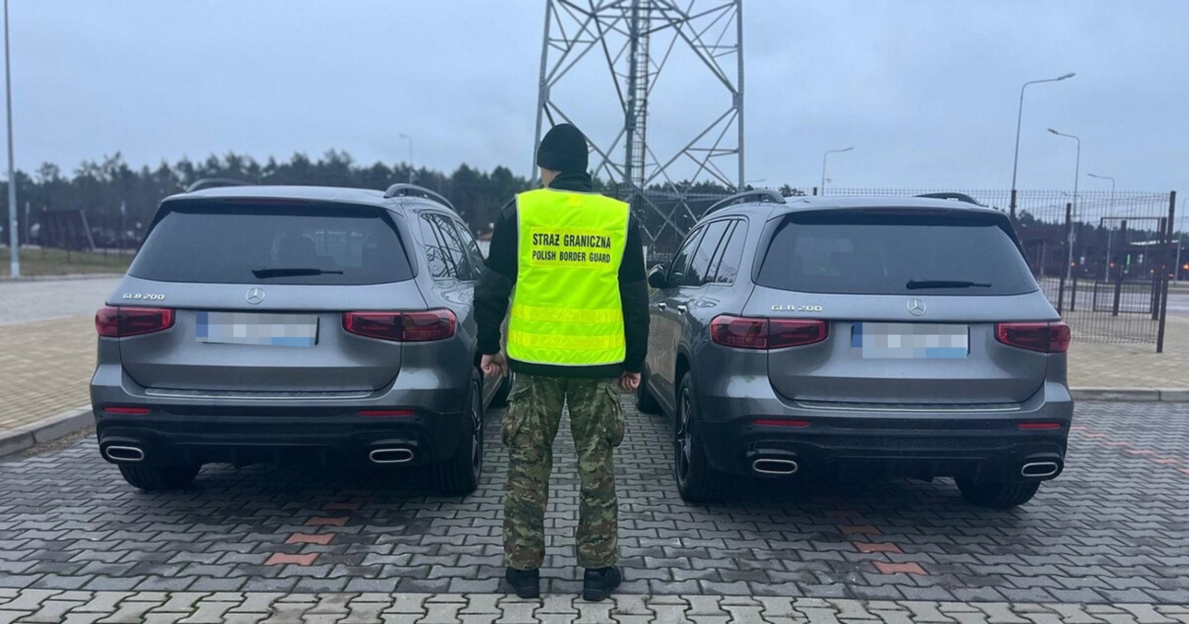 Funkcjonariusz SG stoi przy dwóch Mercedesach