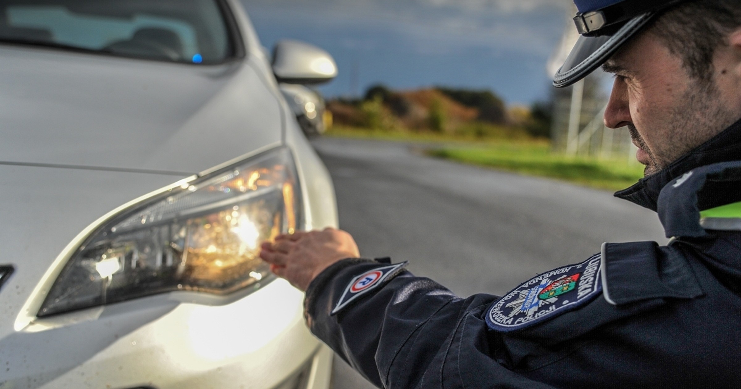 Policjant sprawdza światła podczas kontroli drogowej